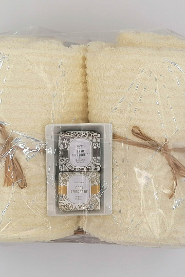 Coffret cadeau de serviettes dans un plateau en osier enveloppé dans du cellophane - crème